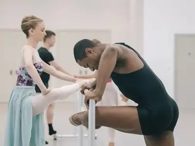 Ballet dancers stretching on the bar